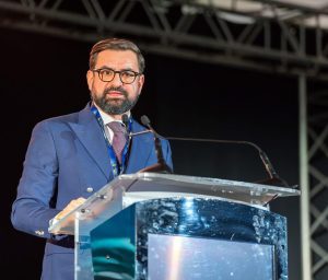 Adrian Chesnoiu vorbind la un pupitru în cadrul unui summit agricol despre energia regenerabilă.