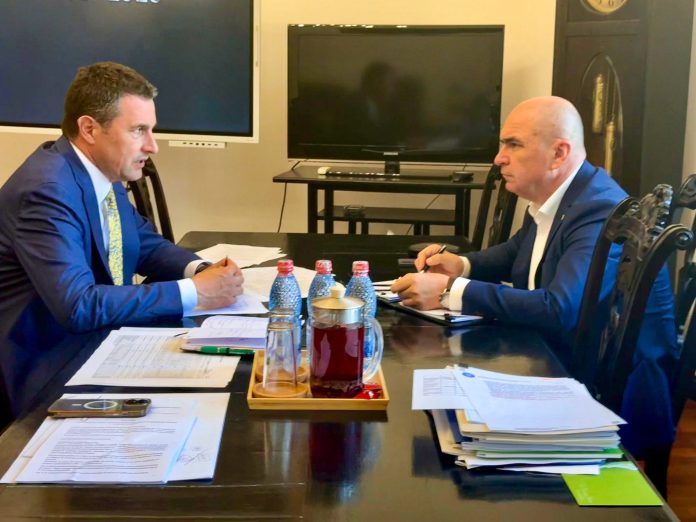Premierul Ilie Bolojan și reprezentantul Ministerului Agriculturii la o masă de lucru cu documente, discutând despre subvențiile pentru fermieri.