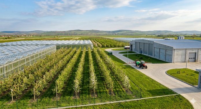 Fotografie panoramică a unui complex horticol modern din România, finanțat prin AFIR, cu livezi, sere și facilități de procesare. Un panou mare afișează investițiile de peste 1 miliard de euro.