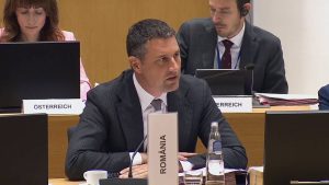 Ministrul interimar al agriculturii din România, Tánczos Barna, vorbind la microfon în cadrul reuniunii Consiliului UE de la Bruxelles, având în față plăcuța oficială cu numele țării.