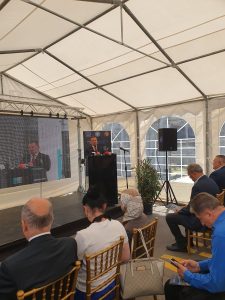 Vorbitor la tribună în interiorul unui cort de evenimente din Portul Constanța, cu o audiență așezată, în timpul inaugurării extinderii capacității de depozitare a cerealelor.