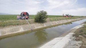 Canalul Siret-Bărăgan plin cu apă în timpul utilizării unei motopompe pentru irigarea culturilor agricole.