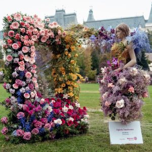 Manechin îmbrăcat în rochie din flori naturale și arcadă florală la expoziția Florall Palas.